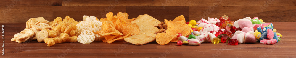 Salty snacks. Pretzels, chips, crackers and candy sweets on table Salty snacks. Pretzels, chips, crackers and candy sweets on table