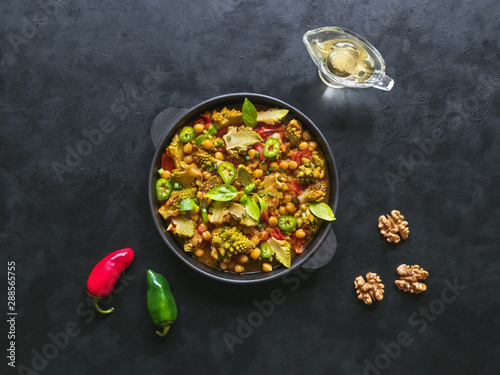 Nutty roasted romanesco curry in a black background. Top view. 
