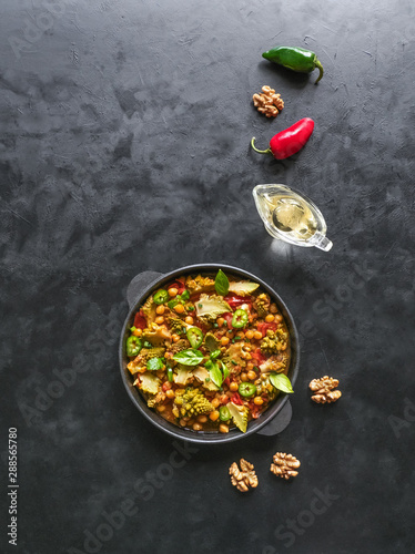 Nutty roasted romanesco curry in a black background. Top view. 