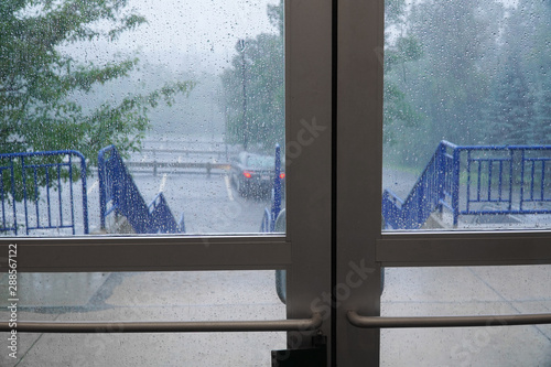 parking lot in heavy rain outside building glass door