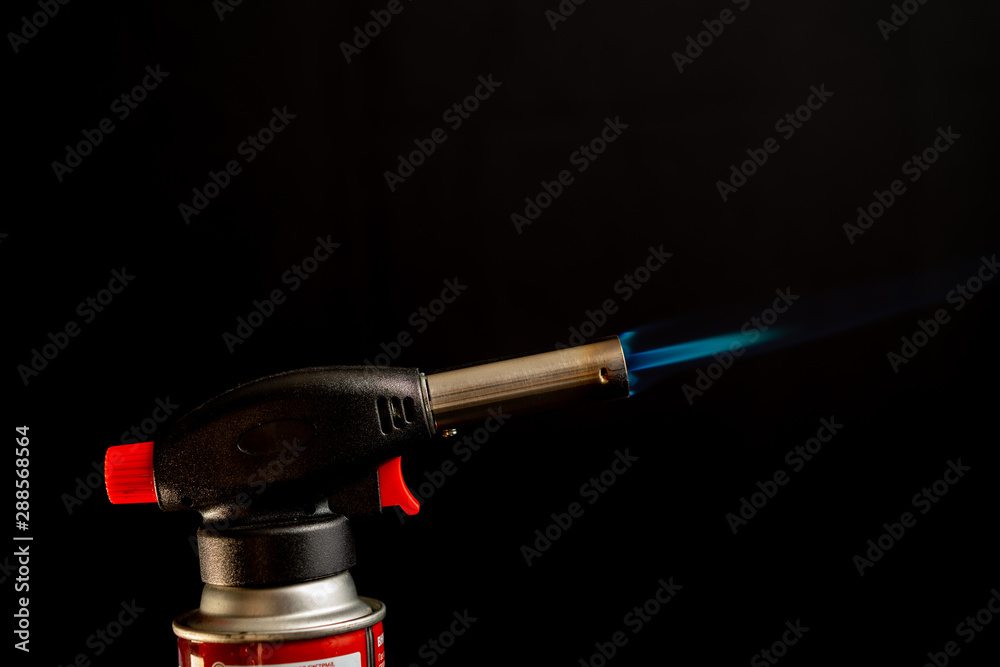 Naklejka premium Flame gas burner dark background DIY tools