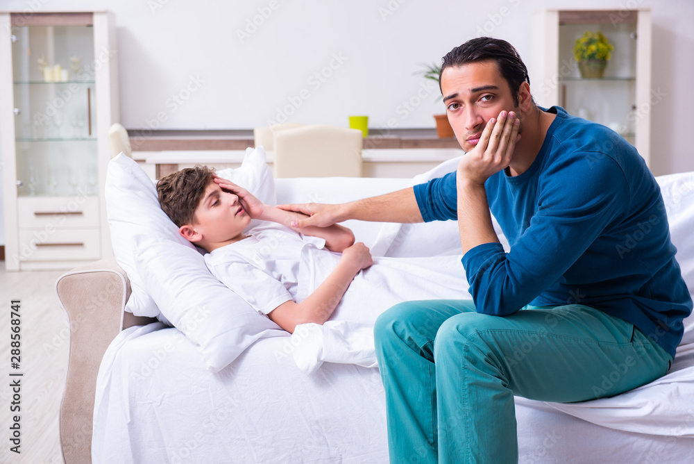 Obraz premium Young father caring for sick son