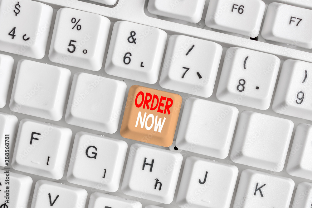 Writing note showing Order Now. Business concept for the activity of asking for goods or services from a company White pc keyboard with note paper above the white background Writing note showing Order Now. Business concept for the activity of asking for goods or services from a company White pc keyboard with note paper above the white background