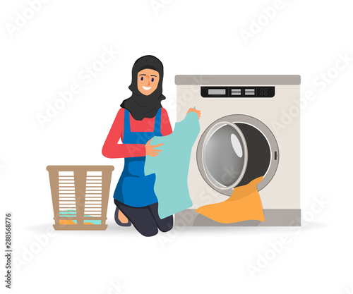Muslim or Arab woman cleaning clothes with laundry washing machine.