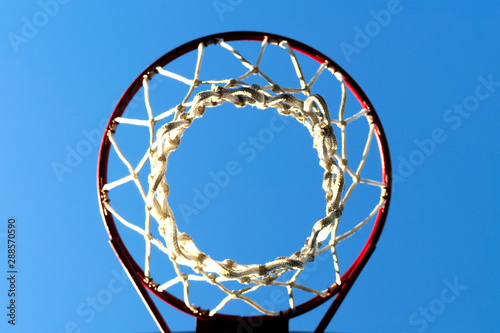 basketball net and hoop outdoors of sunny day against the blue sky, bottom view