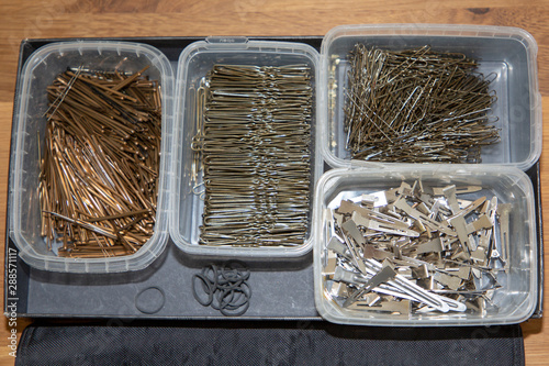 bobby pins scattered different hairpins in batch metal hair clips on workplace of hairdresser photo