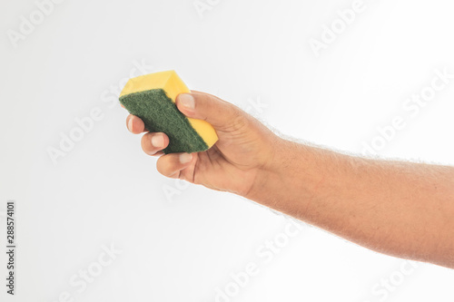 A dishwasher sponge held by a hand on a white background. Space to write.