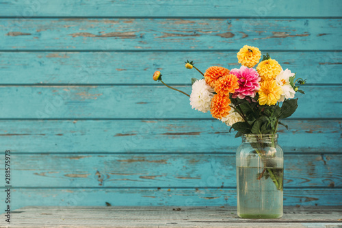 Fall flowers in glass jars standing on the table outside
