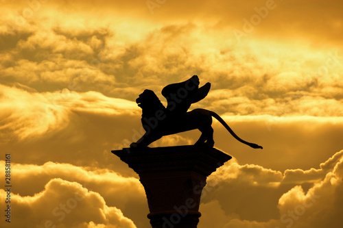 Saint Mark Winged Lion, symbol of the old Venice Republic, old medieval statue among golden clouds