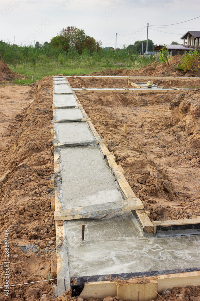 The formwork of the foundation of the future house is strengthened and filled with concrete