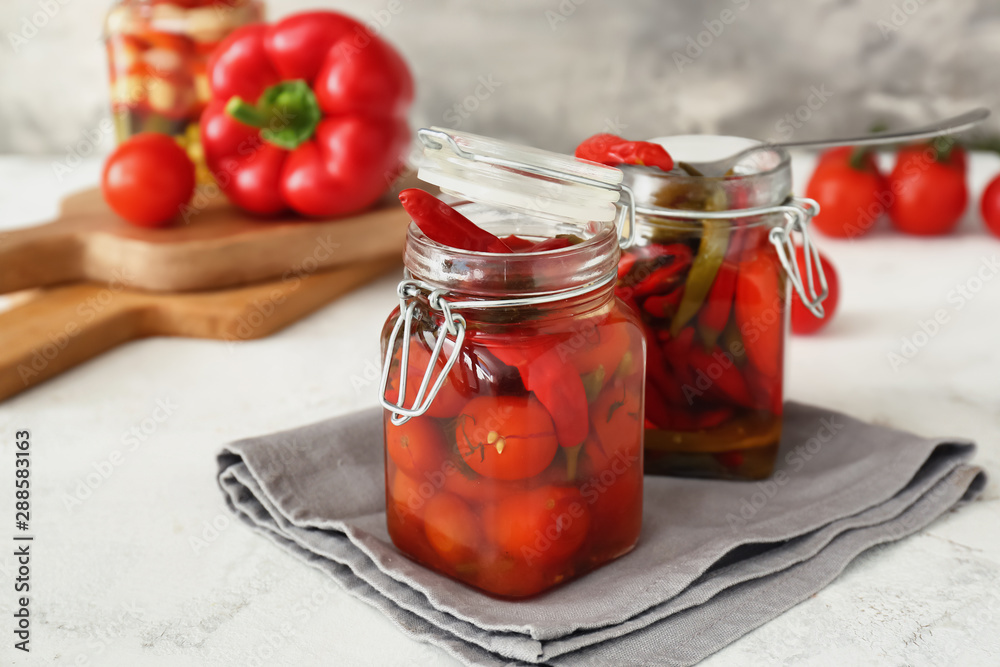 Jars with canned tomatoes and chili pepper on table Stock Photo Adobe