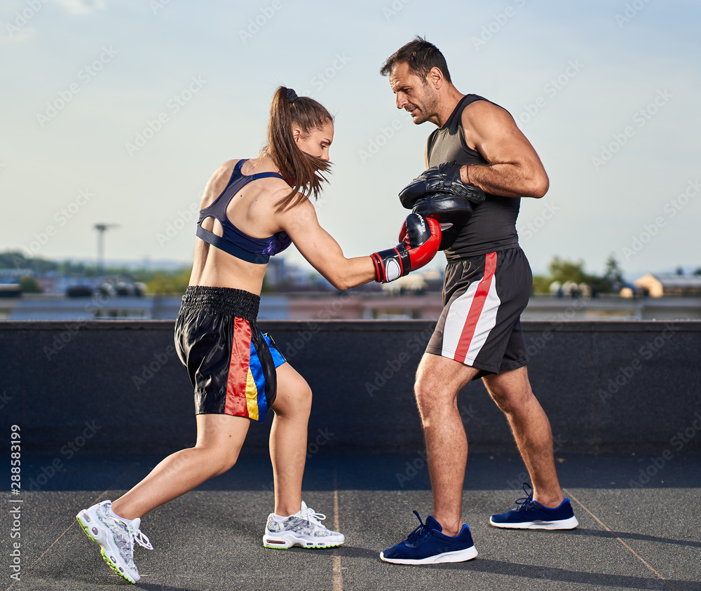 © Xalanx - Young woman boxer hitting pads outdoor © Xalanx - Young woman boxer hitting pads outdoor