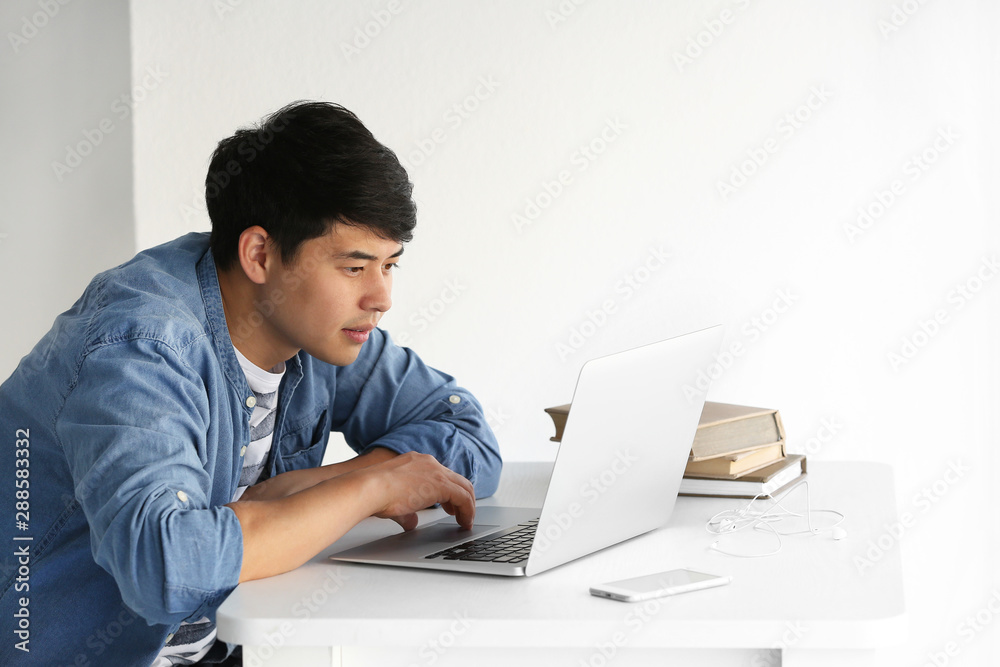 Asian student with laptop preparing for exam at home Asian student with laptop preparing for exam at home