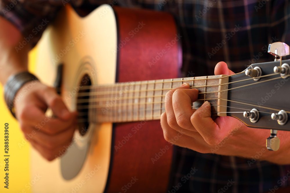 Fototapeta premium Handsome man playing guitar, closeup