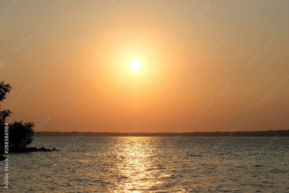 Sunset on the background of the river and the horizon where you can see the city. Sunset on the background of the river and the horizon where you can see the city.