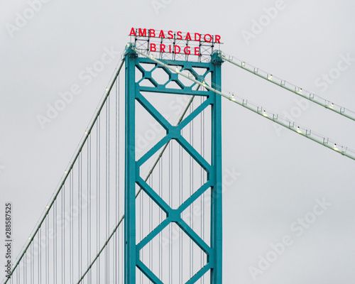 Suspension bridge's name lit on cloudy day photo
