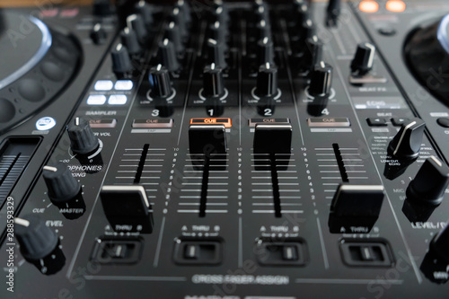 Wide angle photo of black sound mixer controller with knobs and sliders