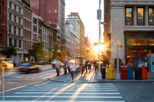 Man walking through the crosswalk at the busy intersection of 5th Avenue and 23rd Street in New York City with sunset background © deberarr