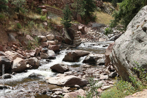 river flowing over rocks with trees on either side