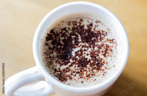 Cappuccino in a white mug. Coffee with foam and chocolate mug in a white mug. Good morning. Morning cappuccino for breakfast. Coffee in a mug top view.
