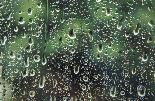 Dripping down drops of rain on glass
