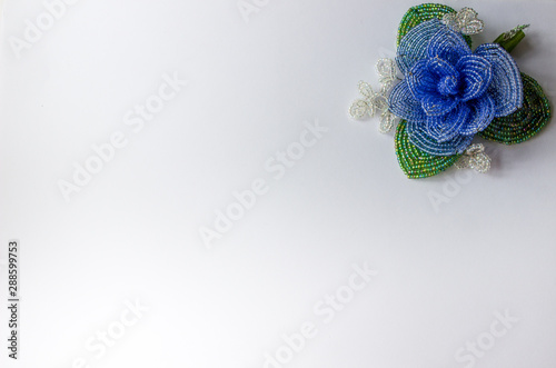 Blue bead flower in the upper right corner of the white background. Flower from blue beads on a white background.