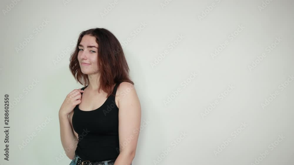 beautiful girl in black tank top over isolated white background shows emotions beautiful girl in black tank top over isolated white background shows emotions