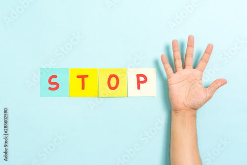 Fototapeta Naklejka Na Ścianę i Meble -  Stop sign concept with hand palm raised on blue background