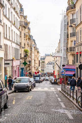 Street with shops and restaurants and residential buildings in Paris