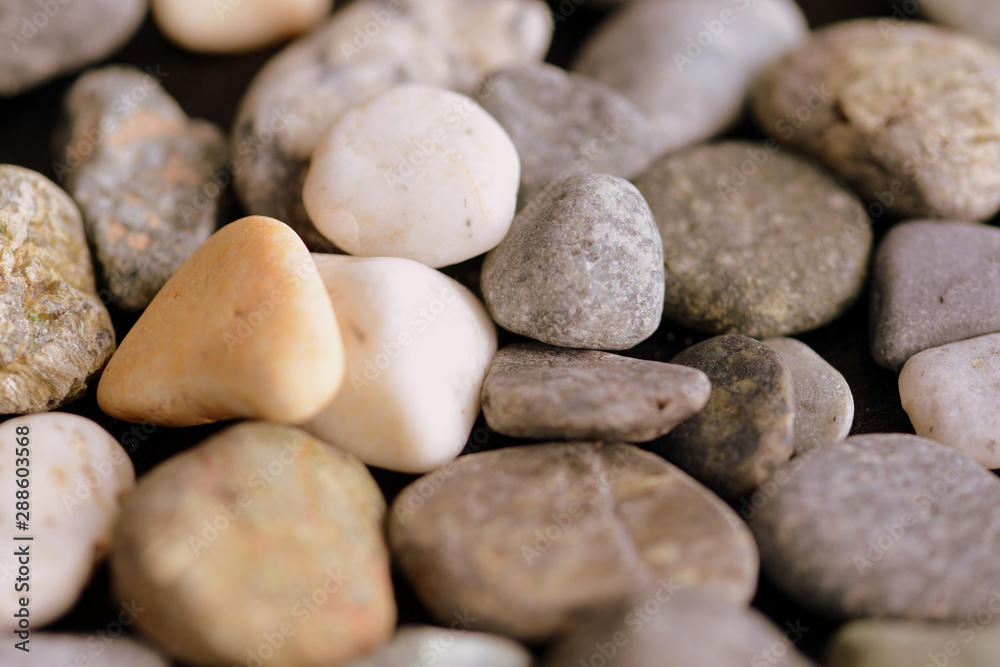 Scattered pebble stones on a dark background close up Scattered pebble stones on a dark background close up
