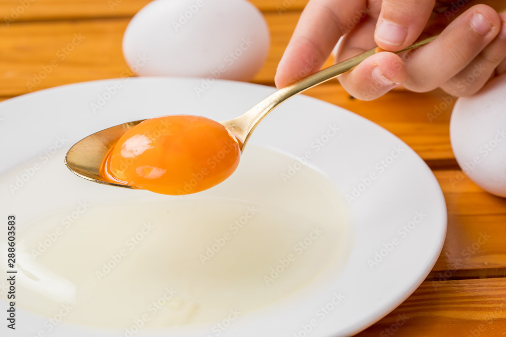 白いお皿に生卵の黄身がスプーンから落ちる瞬間 料理 Stock Photo Adobe Stock