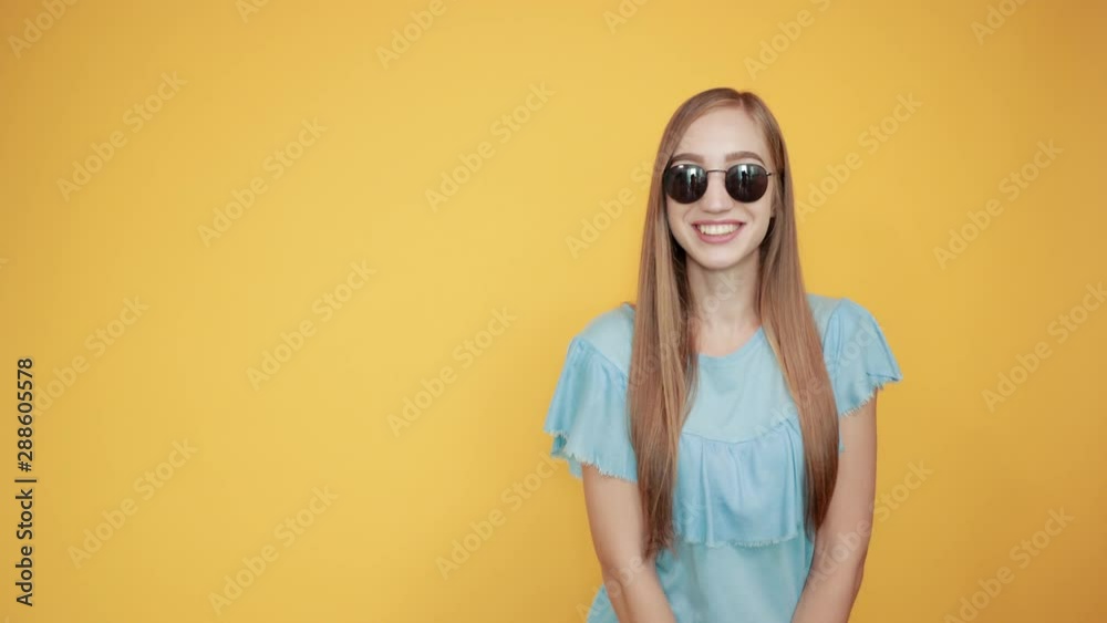 girl brunette in blue t-shirt over isolated orange background shows emotions