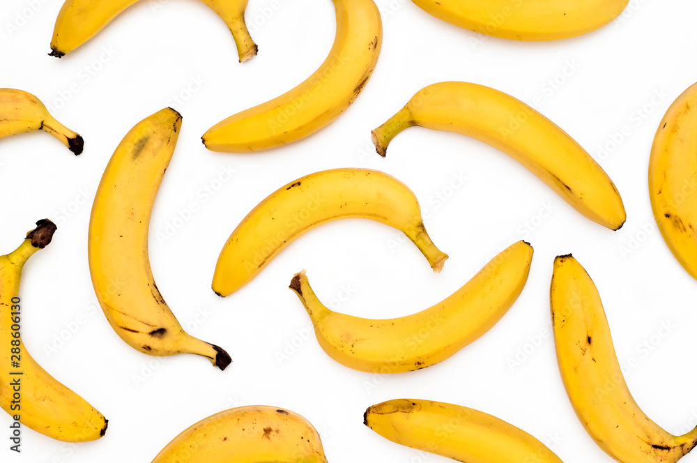 Bright yellow scattered bananas on a white background.  Top View.