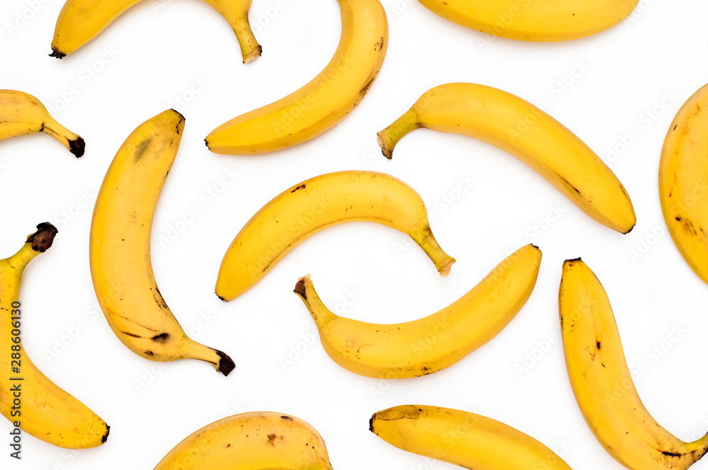 Bright yellow scattered bananas on a white background. Top View. Bright yellow scattered bananas on a white background. Top View.