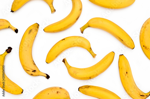 Bright yellow scattered bananas on a white background. Top View.
