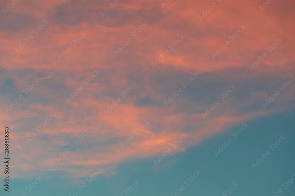 Teal and orange cloudy sky background.