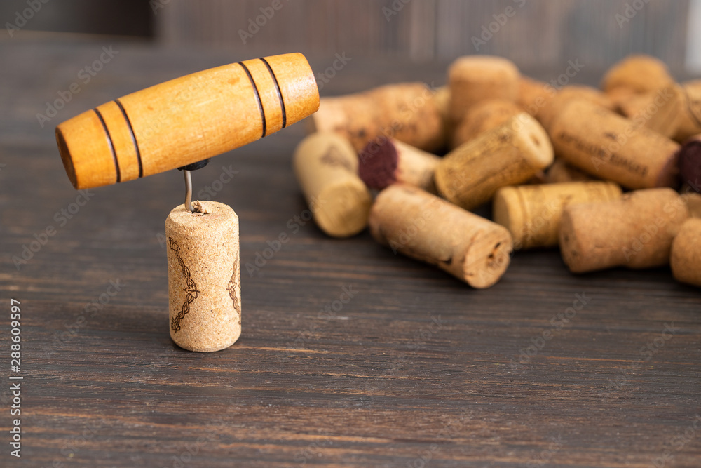 Used wine corks and corkscrew on wooden background.Wine drinking concept.