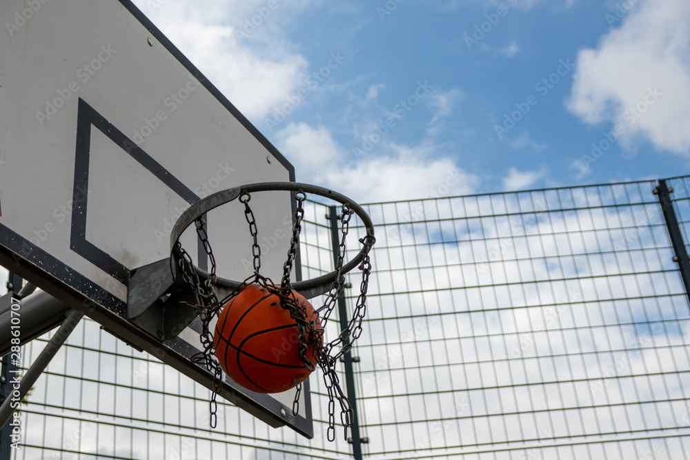 Outdoor-Basketballkorb unter freiem blauen Himmel lädt zum Basketball spielen und Körbe werfen ein zur Erholung, als sportliche Aktivität, Mannschaftssport, Streetball oder Basketball-Turnier