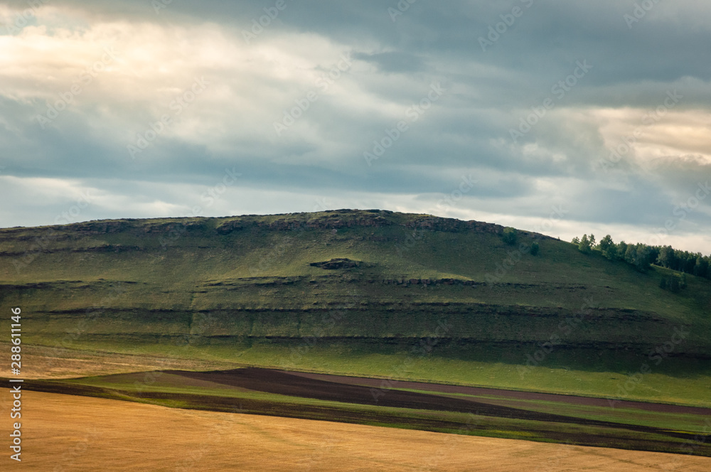 Agricultural fields, meadows and grass hills in steppe at Khakassia, Siberia, Russia.