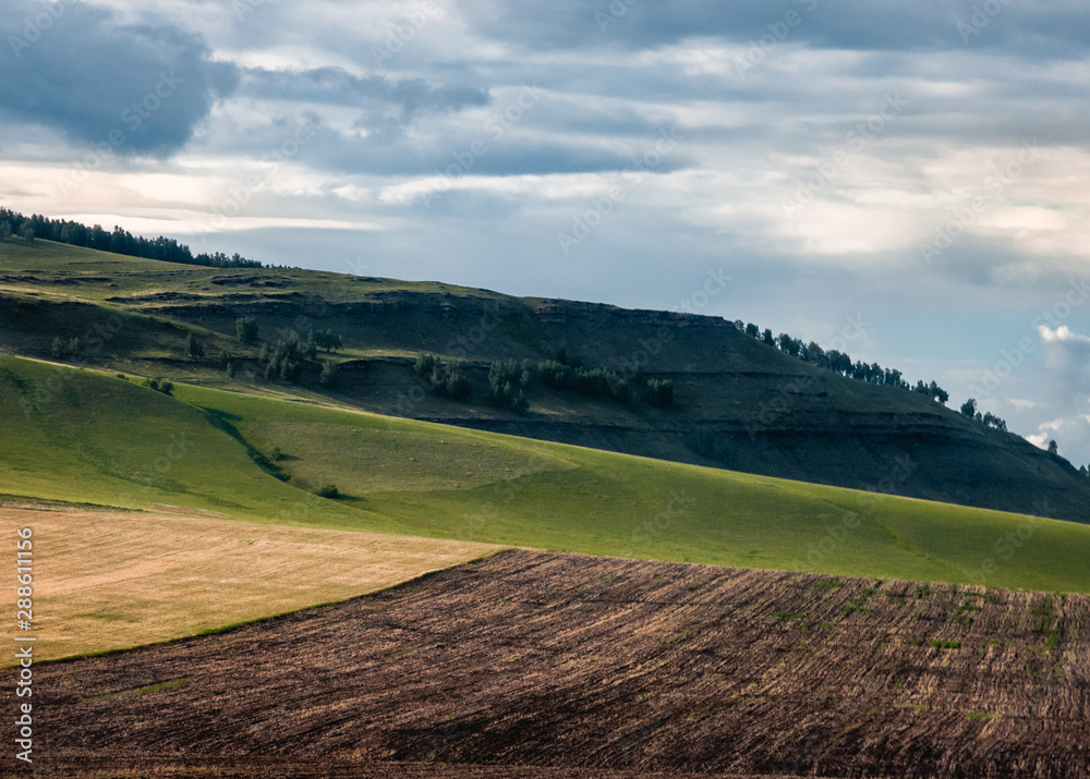 Agricultural fields, meadows and grass hills in steppe at Khakassia, Siberia, Russia.