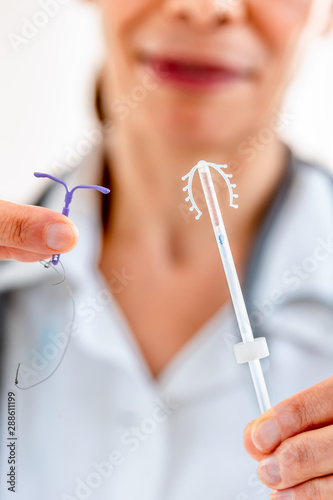Female doctor holding two knd of intra utreine devine for birth control IUD
