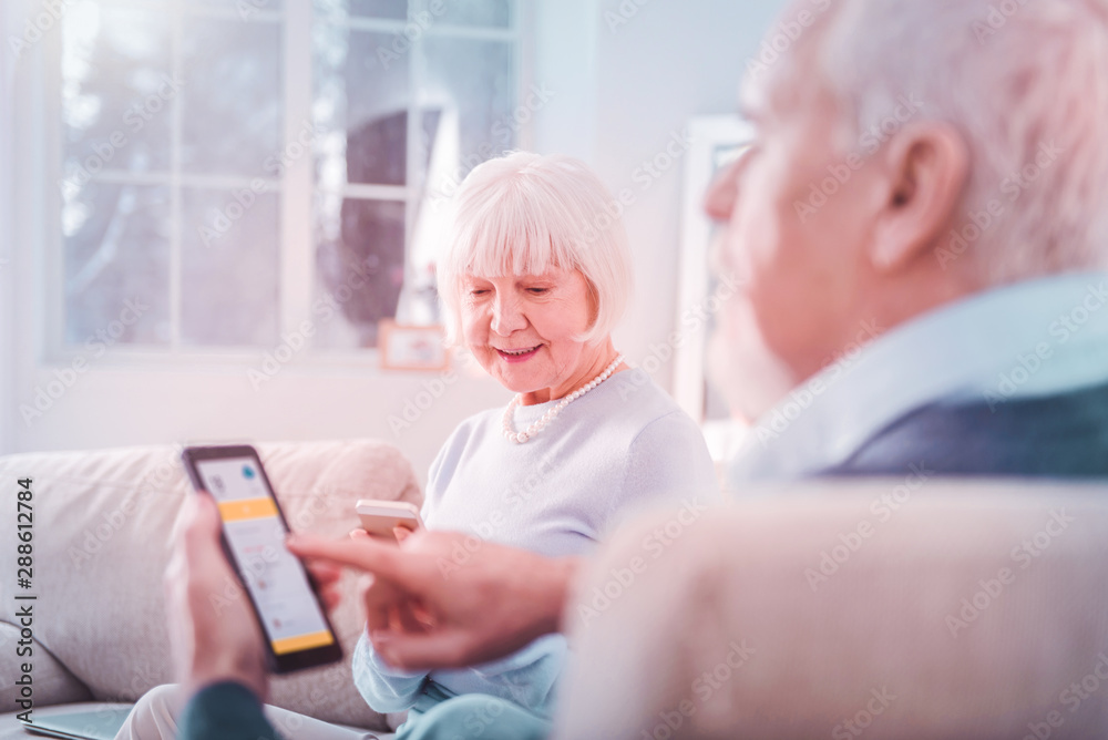Obraz premium Beautiful grey-haired wife sitting near her bearded retired husband