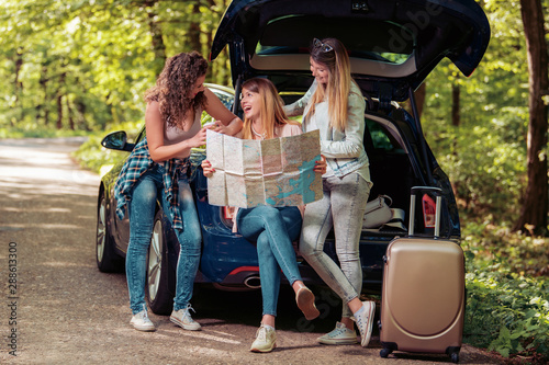 Friends tourists with map in car trunk © ivanko80