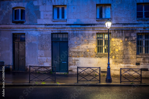 Fototapeta Naklejka Na Ścianę i Meble -  The light of lonely street lamp on the evening street of Paris after the rain