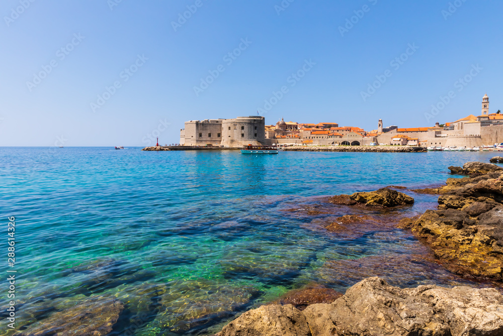 Historical city walls of Dubrovnik seen from a nearby beach