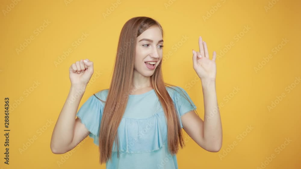 girl brunette in blue t-shirt over isolated orange background shows emotions girl brunette in blue t-shirt over isolated orange background shows emotions