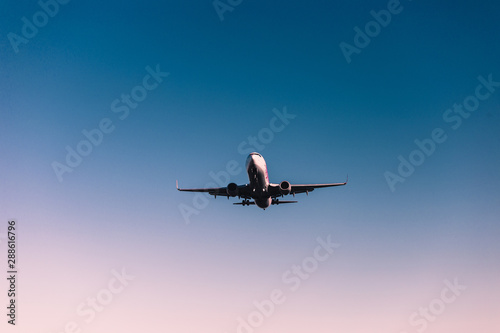 The plane is landing. Airplane in the sky. Coral blue gradient.