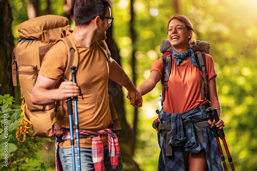 Cheerful couple hiking together in forest