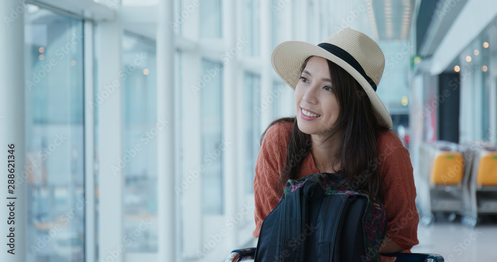 Happy woman waiting for her flight in the airport Happy woman waiting for her flight in the airport