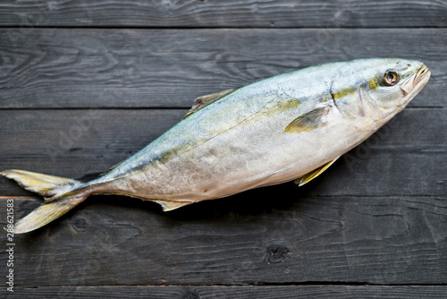 Fresh tuna on a wooden black background, top view.